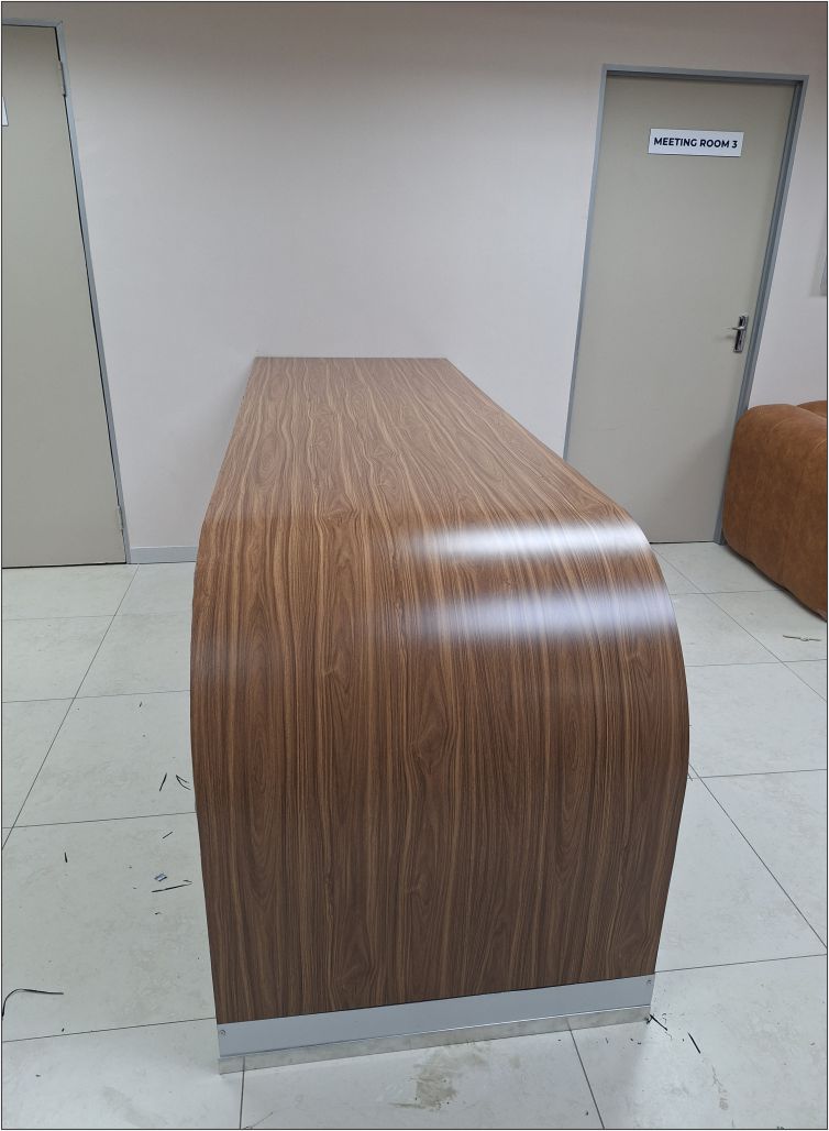 Custom-designed shopfitted reception counter with a modern wood-grain finish, fabricated and installed by Specifusion for a commercial interior in Mokopane, Limpopo